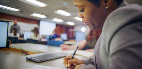 Doctoral candidates taking notes during a lecture.