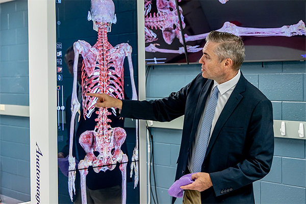 Dr. Balza gestures toward a full-body digital anatomical rendering on CUW’s Anatomage table.