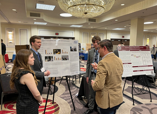 Students discussing project with APEE attendee